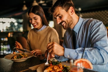 A happy couple enjoying a healthy meal in a restaurant.