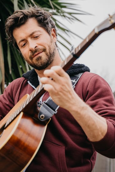 a man playing a guitar and singing into a microphone
