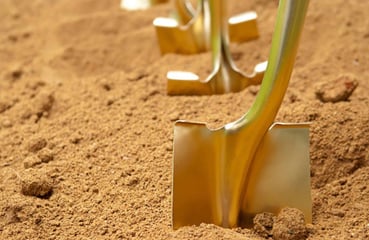 gold spades lined up in tanned earth waiting for the internment proceedings to start