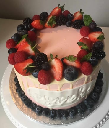 a cake with berries and berries on a white plate