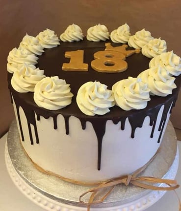 a cake with white frosting and chocolate icing