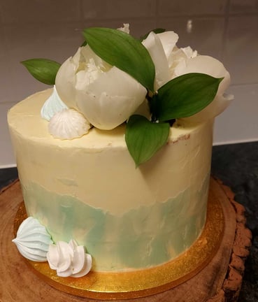 a cake with white flowers on top of a wooden board