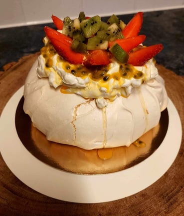 a cake with fruit on top of a wooden board