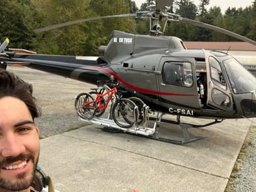 a man standing next to a helicopter with bikes