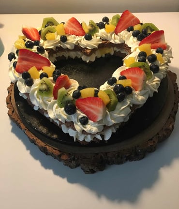 a cake with fruit on top of a wooden slice