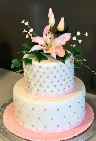 Elegant celebration cake decorated with refined details, available in chocolate or vanilla perfect for birthdays, weddings