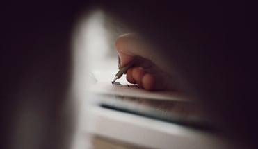 a person writing on a piece of paper