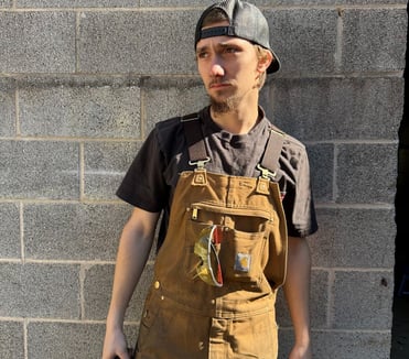 jaspar schirmer standing by a wall in his welding gear