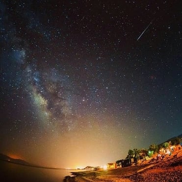 um céu noturno com estrelas e uma estrela cadente