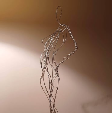 A wire sculpture of a complete female figure, standing with hands on hips