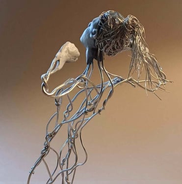 A wire sculpture of a complete kneeling female figure with clay hands, face and feet, arms raised