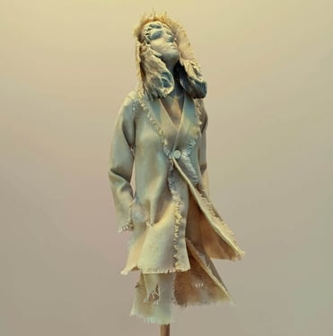 Clay and canvas sculpture of a female figure gazing upwards, wearing windswept, ragged clothes.