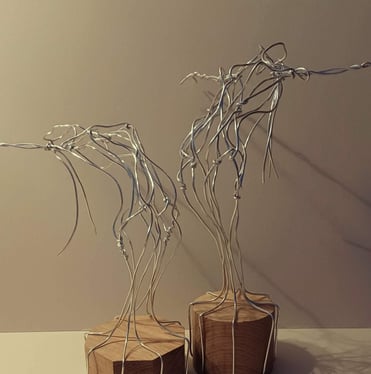 Two similar wire sculptures of complete female figures, standing, bending over backwards, arms out