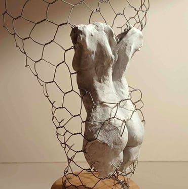 A clay female torso surrounded by wire netting, painted in neutral colours