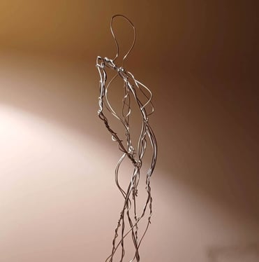 A wire sculpture of a complete female figure, standing with hands on hips