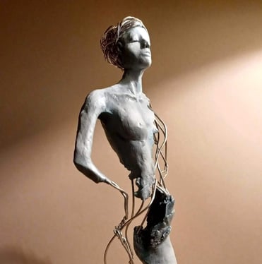 A complete sculpture of a standing female figure, part clay, part wire, hands on hips