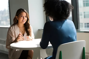 Discussion between two women at Admit 360 Edu Abroad Solutions, emphasizing tailored profile 