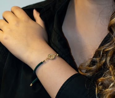 a woman wearing a black shirt and a gold bracelet