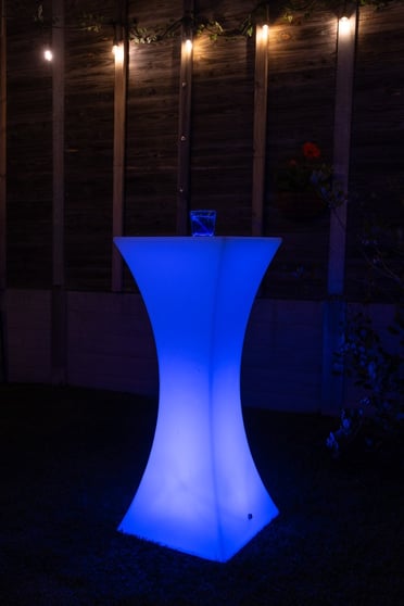 Glowing blue cocktail table in the backyard of an event in Redlands.