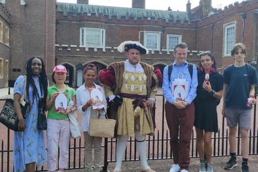 a group of people standing in front of St James's Palace with Henry VIII