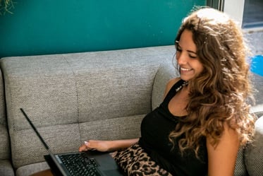 a woman sitting on a couch with a laptop