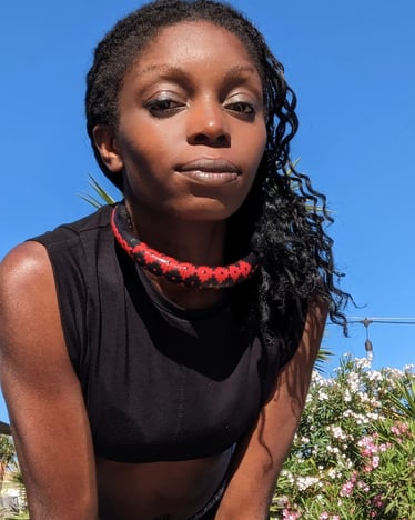 carmel zoum dancehall reggae reggaeton a woman with a red necklace and a black top
