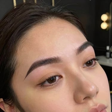 A vibrant photo showcasing expertly applied makeup highlighting natural beauty with gold and black accents.