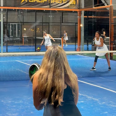 Mujeres jugando pádel en cancha de club deportivo