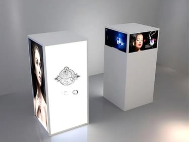 Modern white illuminated retail display pedestals featuring backlit jewelry advertisements.