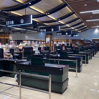 Modern grocery store checkout counters with electronic payment signs and digital displays in a retail supermarket.