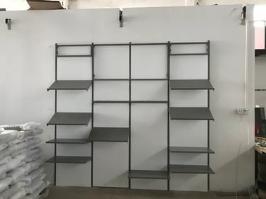 Industrial gray metal wall shelving unit with adjustable storage racks and display shelves.