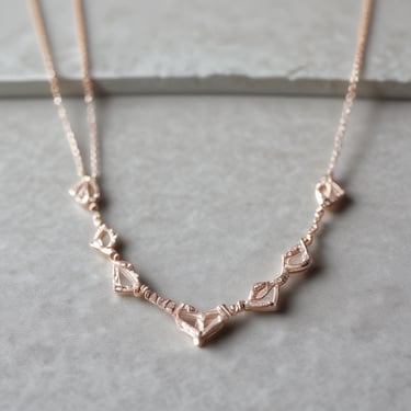 An elegant display of vintage clothing and unique accessories arranged on rustic wooden shelves.