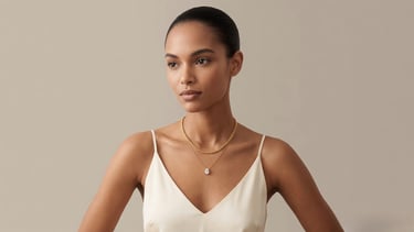 Elegant woman wearing a layered gold chain and diamond pear pendant necklace.