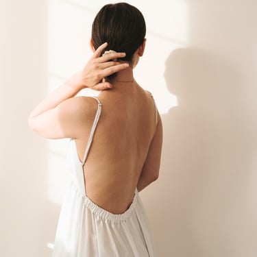 A woman wearing a backless dress to showcase fashion solutions and lingerie accessories