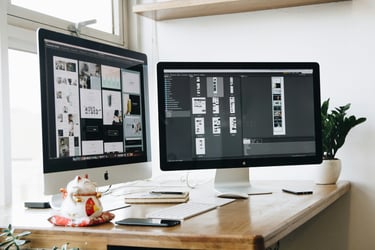 Escritorio con doble pantalla mostrando wireframes de diseño web estratégico