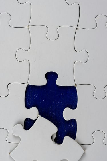 white jigsaw puzzle with missing piece nearly in place