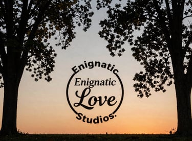 An outdoor shot of two elegant trees framing a horizon at sunset in Maryland, reflecting the Enigmatic Love Studios emblem.