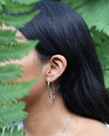 Aretes largos plateados usados por una mujer