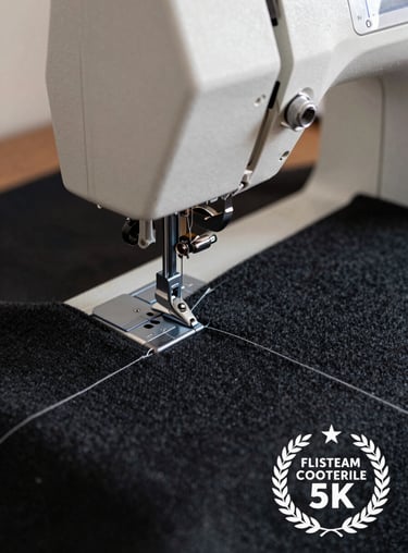 Close-up of a modern sewing machine stitch line on a heavy charcoal black wool fabric.