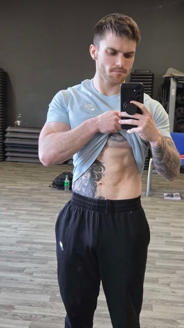 Level 4 sports massage therapist TJay Harvey highlighting abdominal anatomy in a gym.