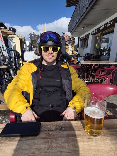 TJay Harvey relaxing outdoors in winter gear during a skiing and snowboarding trip.