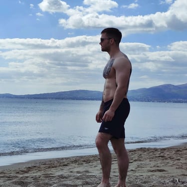 Sports therapist TJay Harvey demonstrating athletic physical conditioning on a beach.