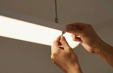 Close-up of a hand installing a high-end light fixture, precision work, warm interior lighting, professional aesthetic.