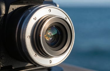Close-up of a professional camera follow-focus gear, metallic textures catching ghost white light, blurred deep ocean blue background.