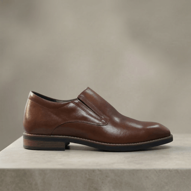 Zapato de vestir de cuero marrón, sin cordones (tipo slip-on) y con una suela fina y elegante
