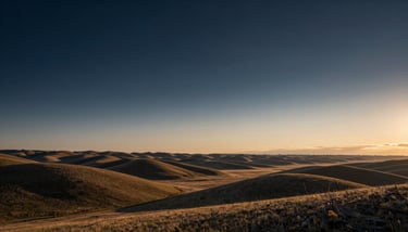 A wide-angle photography shot of a winding river through a Montana valley under a clear, deep navy and slate sky.