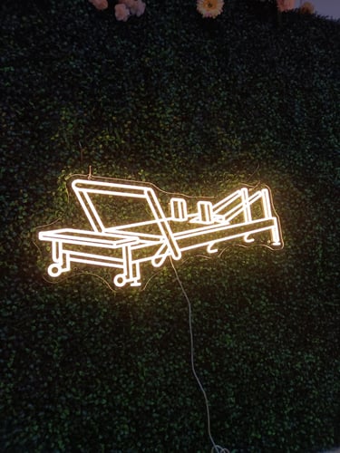 warmweißes LED Neon Schild mit Liegestuhl-Motiv auf dunklem Hintergrund