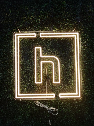 warmweißes LED Neon Logo mit Buchstaben „h“ im Rahmen – Hamppwerk Bäckerei Logo auf dunklem Hintergrund