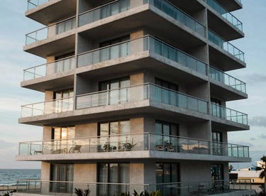 A modern apartment building exterior with glass balconies overlooking the Veracruz coast.