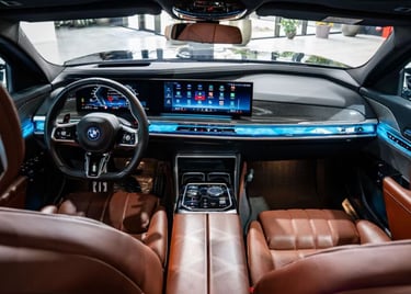 Luxury BMW interior with brown leather seats, a curved digital dashboard, and blue ambient lighting.